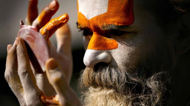 A sadhu (holy man) smearing colourful powder on forehead on the Pashupatinath temple premises, Kathmandu on Thursday. Photo: NAVESH CHITRAKAR